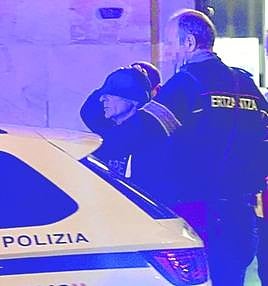 El hombre es introducido en un coche policial tras su detención.