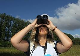 Una mujer observa a las aves de Salburua.