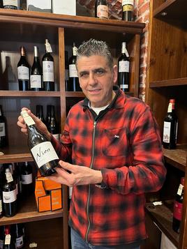 Isi Martínez posa con uno de los vinos que vende.