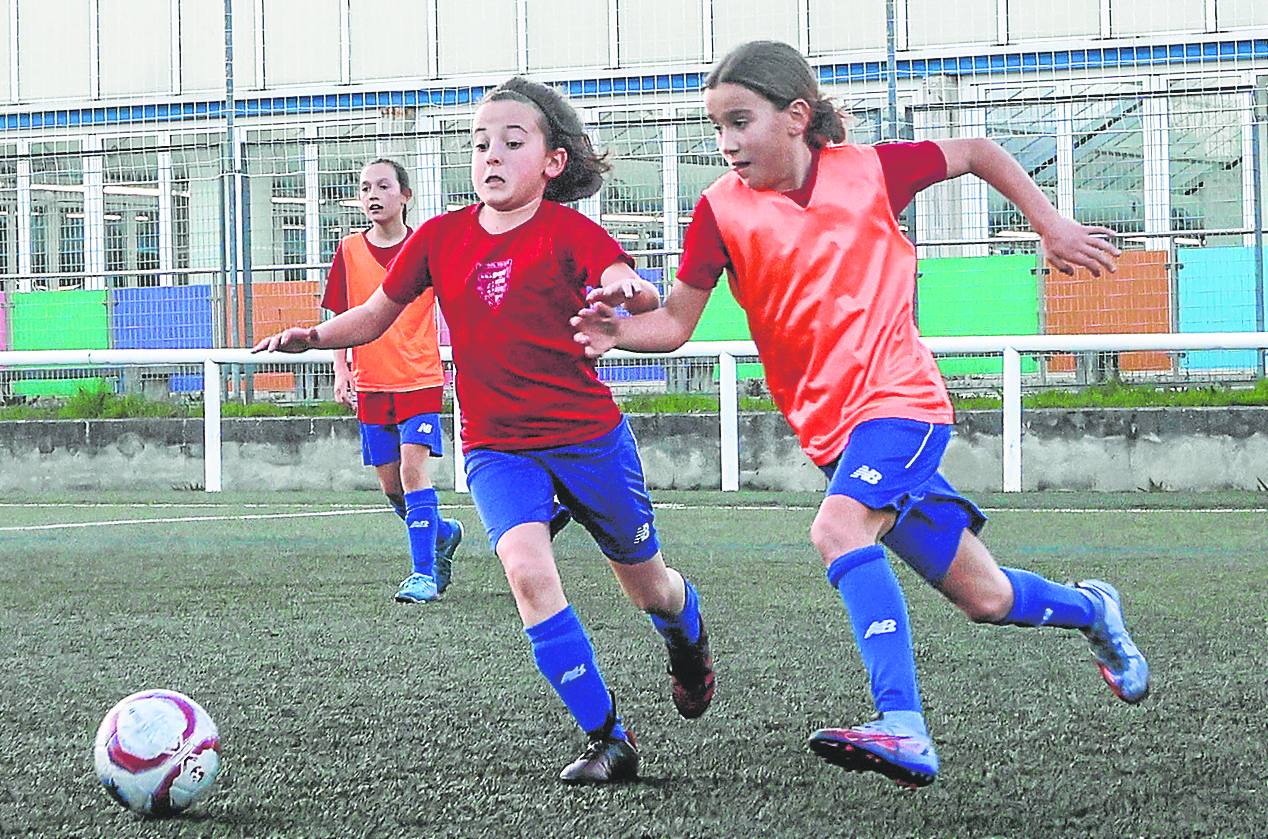 Dos niñas del Bizkerre luchan por el balón en un entrenamiento.