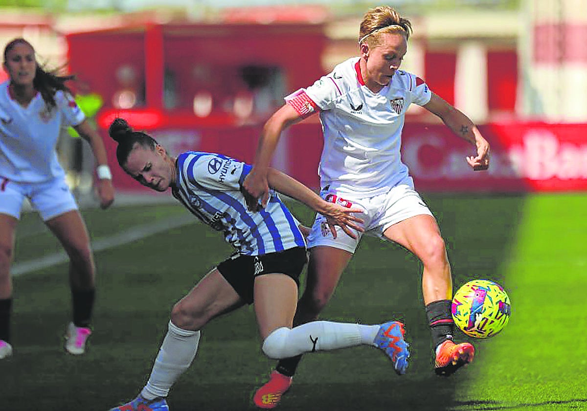 Carla Armengol trata de quitarle el balón a la capitana del Sevilla, Amanda Sampedro.