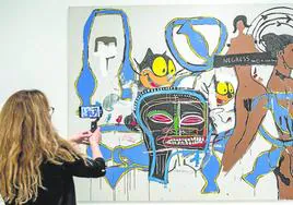 Una visitante fotografía 'Felix the cat', pintado en 1985 por Basquiat y Warhol.