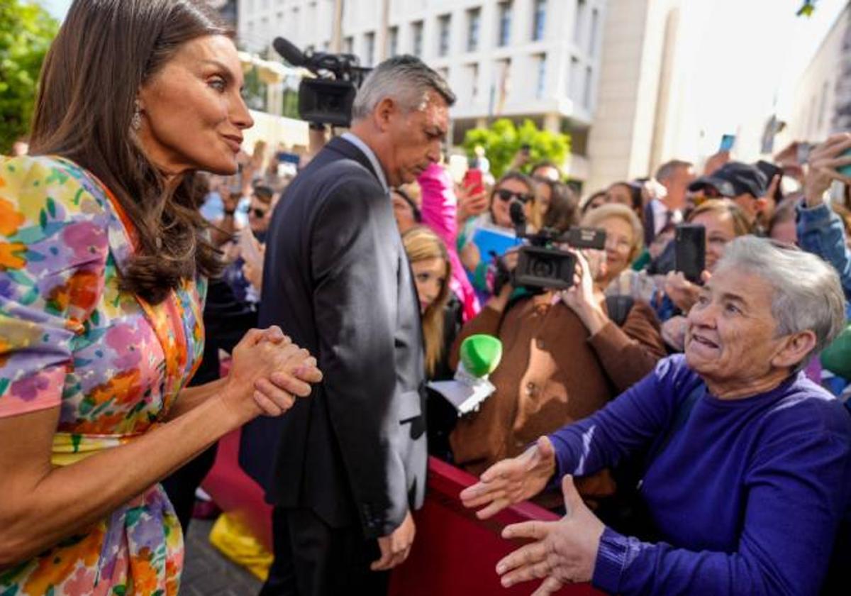 La reina Letizia escucha a la señora en cuestión.