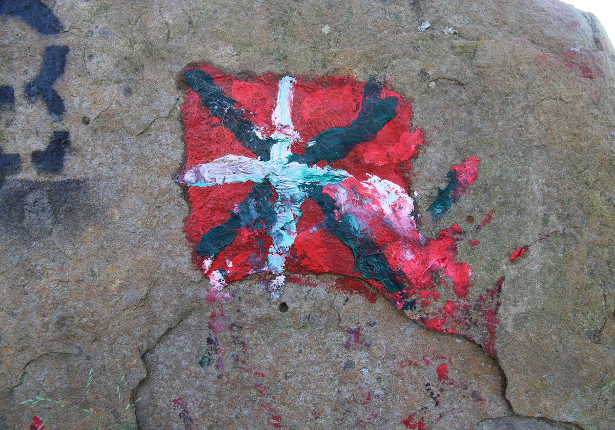 Pintada de al ikurriña en la losa de la cámara funeraria de Katillotxu I.