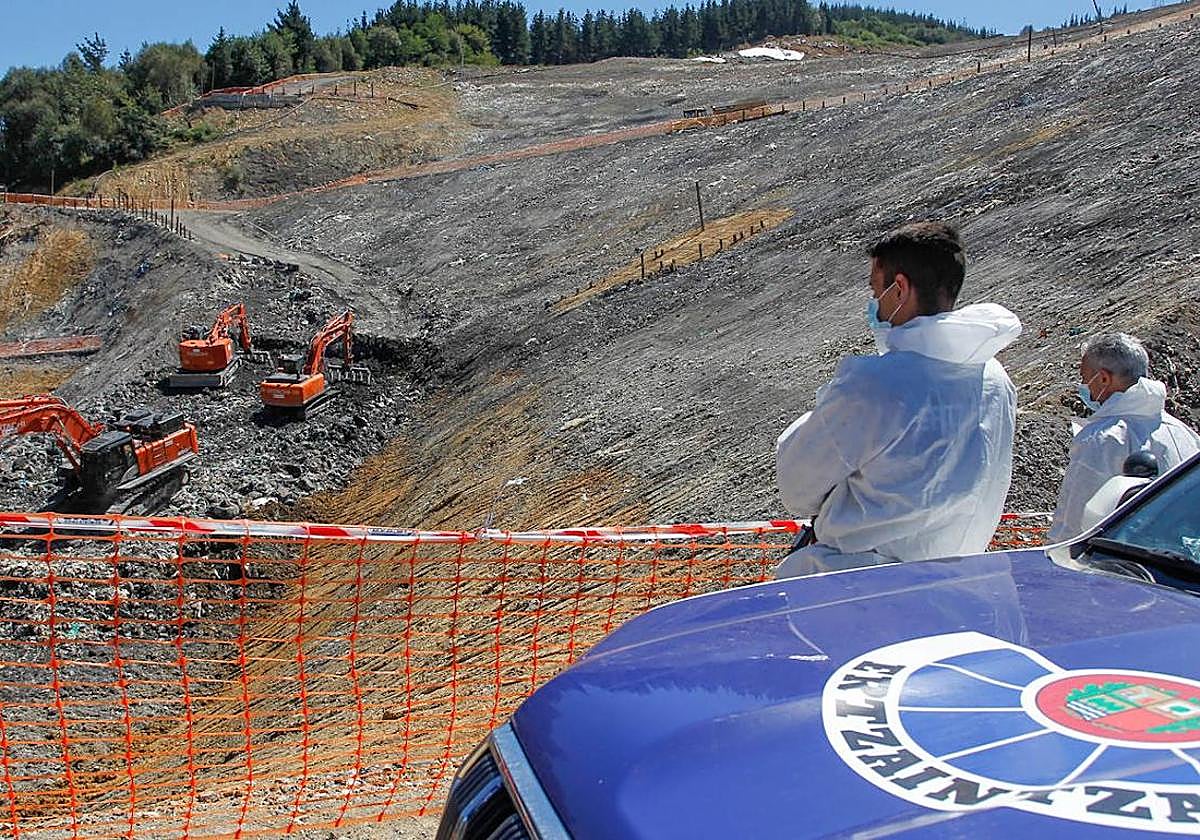 Control. Dos ertzainas graban el trabajo de excavación.