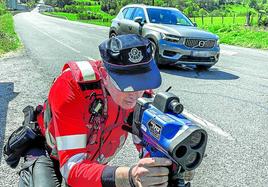 Un agente de Tráfico coloca el radar láser que mide la velocidad de los vehículos.