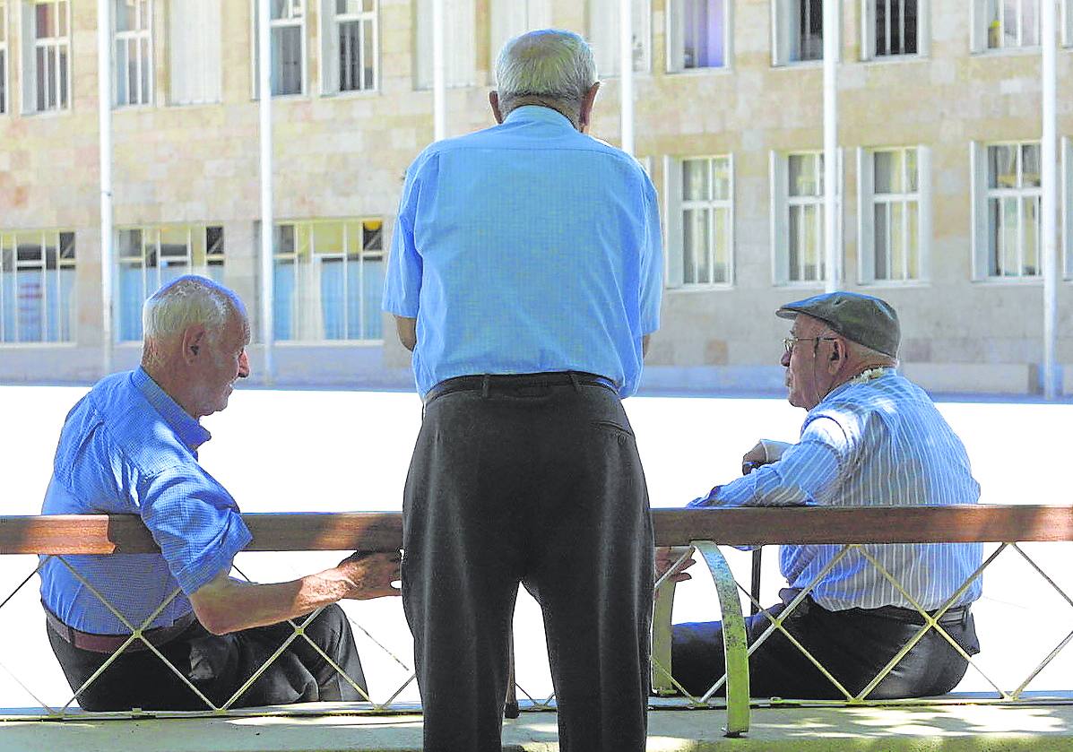 Varios jubilados charlan en una plaza.