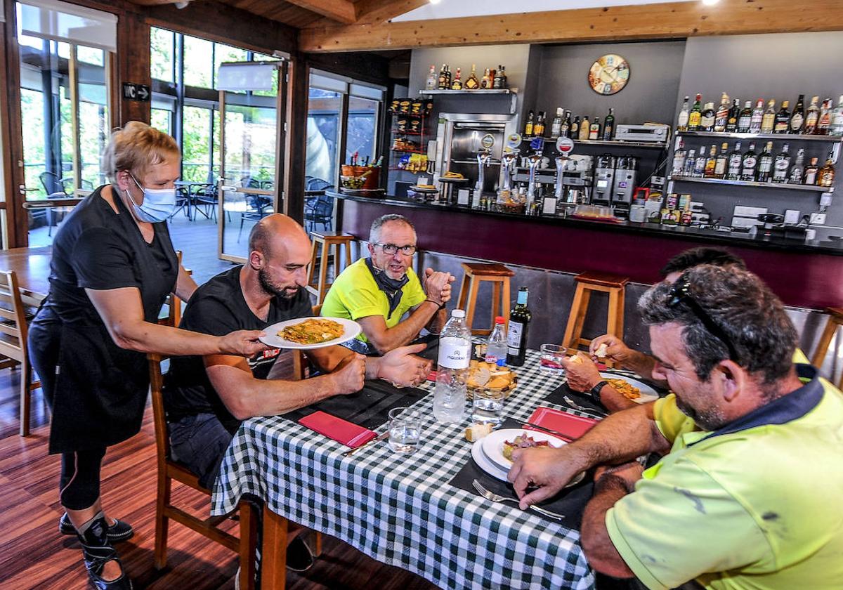 La anterior gerente del local sirve el menú del día a una cuadrilla de trabajadores.