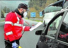 Un ertzaina comprueba el justificante de un conductor en pandemia.