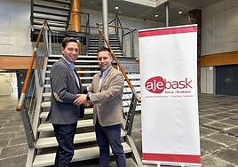 Iñigo Juez (izqda) y Juan Carlos García se estrechan la mano tras el cambio de poderes en Ajebask