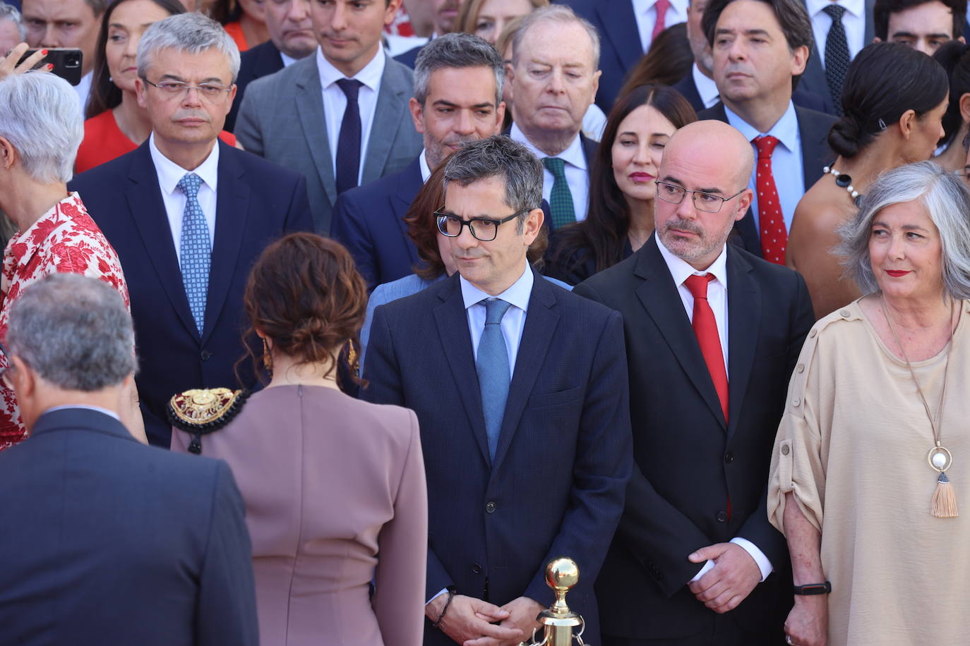 Isabel Díaz ayuso pasa frente a Félix Bolaños en el polémico acto en que no se permitió al ministro subir a la tribuna.