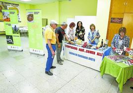 Paneles informativos y una mesa con productos de comercio justo en los salones parroquiales.