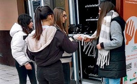 Naia Valero, Natalia Peña, Olatz Atutxa y Ainize Domínguez introducen los platos en la máquina de vending.