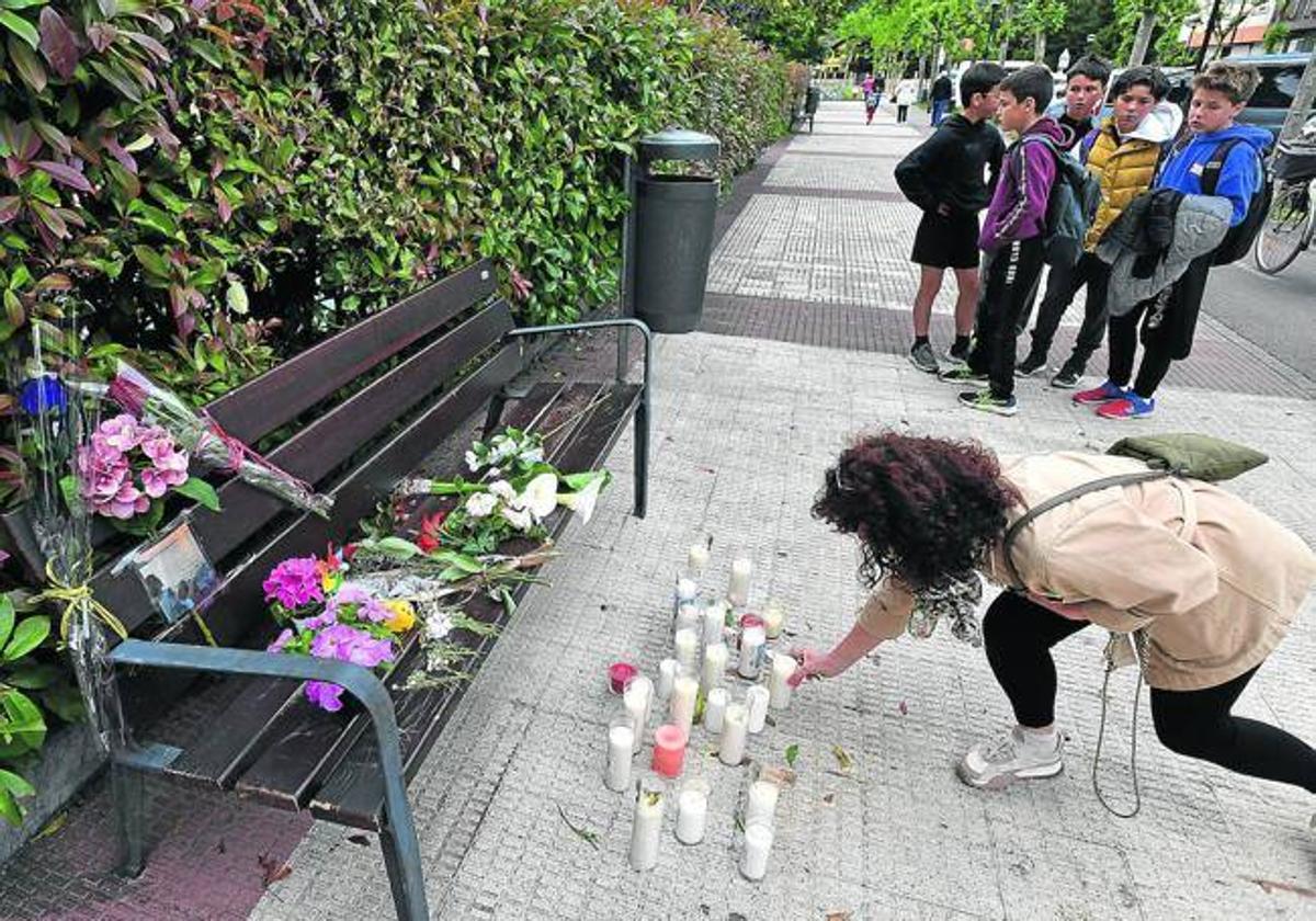 Una mujer coloca una vela ante el banco donde Lourdes del Hoyo esperaba el martes a su expareja, Alberto Casado, que le disparó a bocajarro, sin mediar palabra.