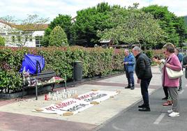 Vecinos de Orio pasan junto al banco de la calle Arrantzale en el que Lourdes fue abatida por su expareja, que después se suicidió.