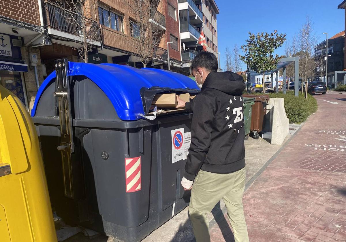 Un joven recicla cartón en un contenedor de Berango.