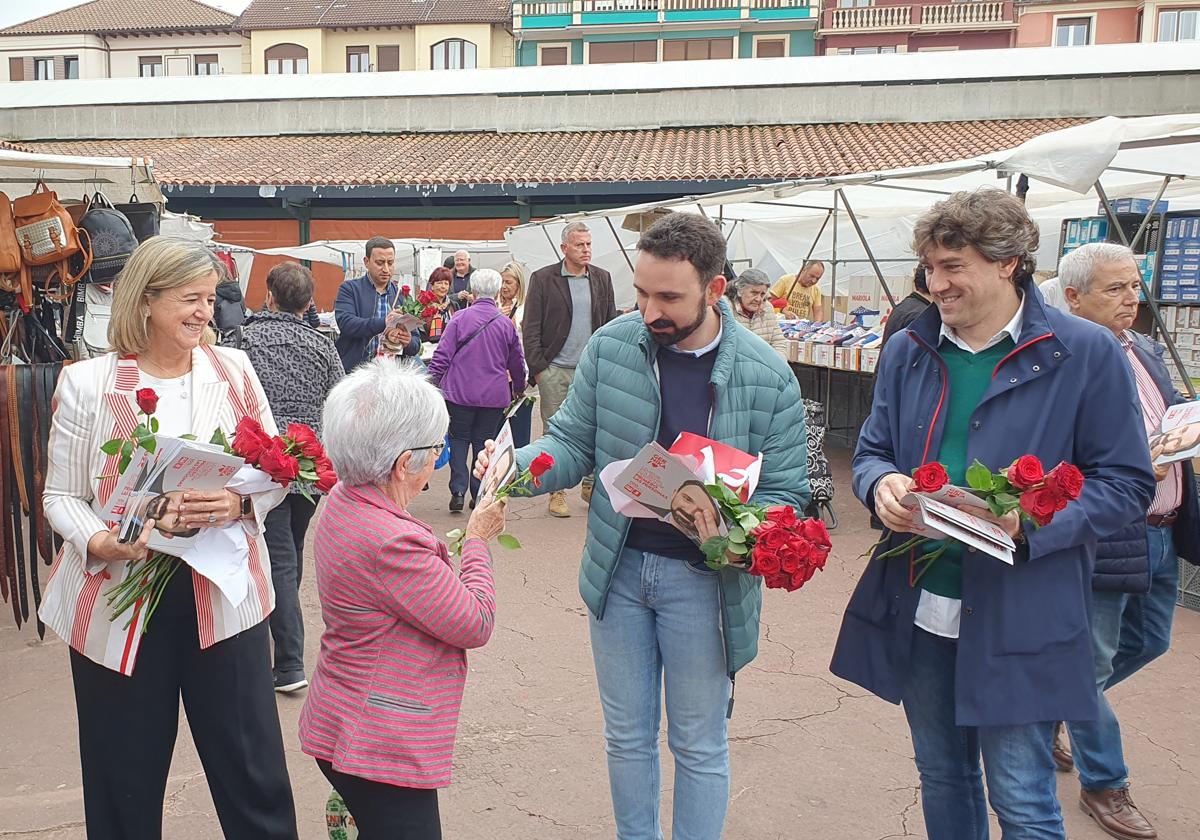 Ander Larrinaga hace entrega de una rosa a una vecina en el mercado de los lunes de Gernika.