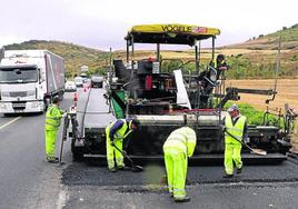 Varios trabajadores participan en el asfaltado de una carretera