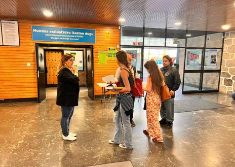 Imagen secundaria 1 - Arriba, ertzainas vigilan un aula en la que no se lograban cubrir los puestos; en la imagen central, suplentes legando a primera hora para conocer si pueden marcharse o deben quedarse, y abajo, uno de ellos, Álex de Benito celebra que ha podido regresar a casa.