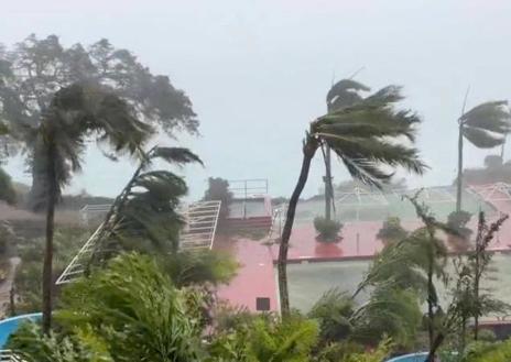 Imagen secundaria 1 - Arriba, una imagen de satélite del tifón 'Mawar'. Abajó, efectos de los vientos en Guam y una imagen de archivo del 'pros'.