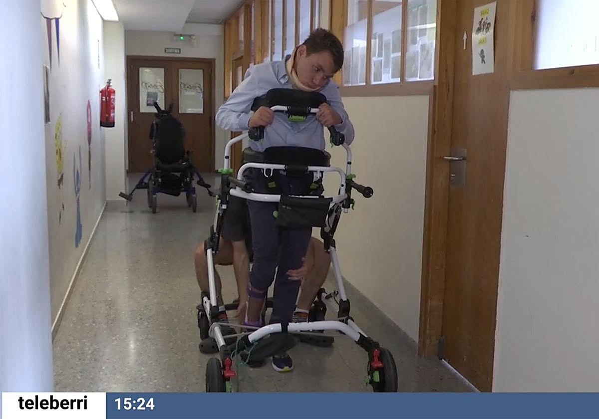 Alex se ayuda de un andador para mantenerse en pie durante su recuperación.