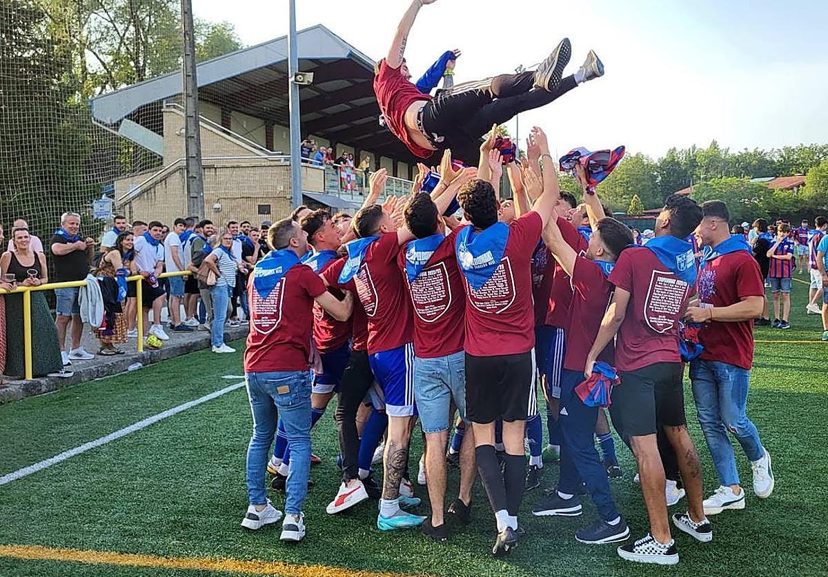 Los jugadores del Derio mantean a su entrenador tras el ascenso.