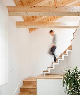 Imagen secundaria 2 - La isla es el elemento sobre el que gira toda la planta primera. La cocina se abre al salón sin impedimentos. Detalle de la escalera que sube hasta el altillo.