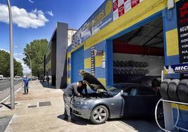 Trabajadores examinan el motor de un vehículo en el taller TecnoCars que se localiza en la calle Portal de Gamarra.