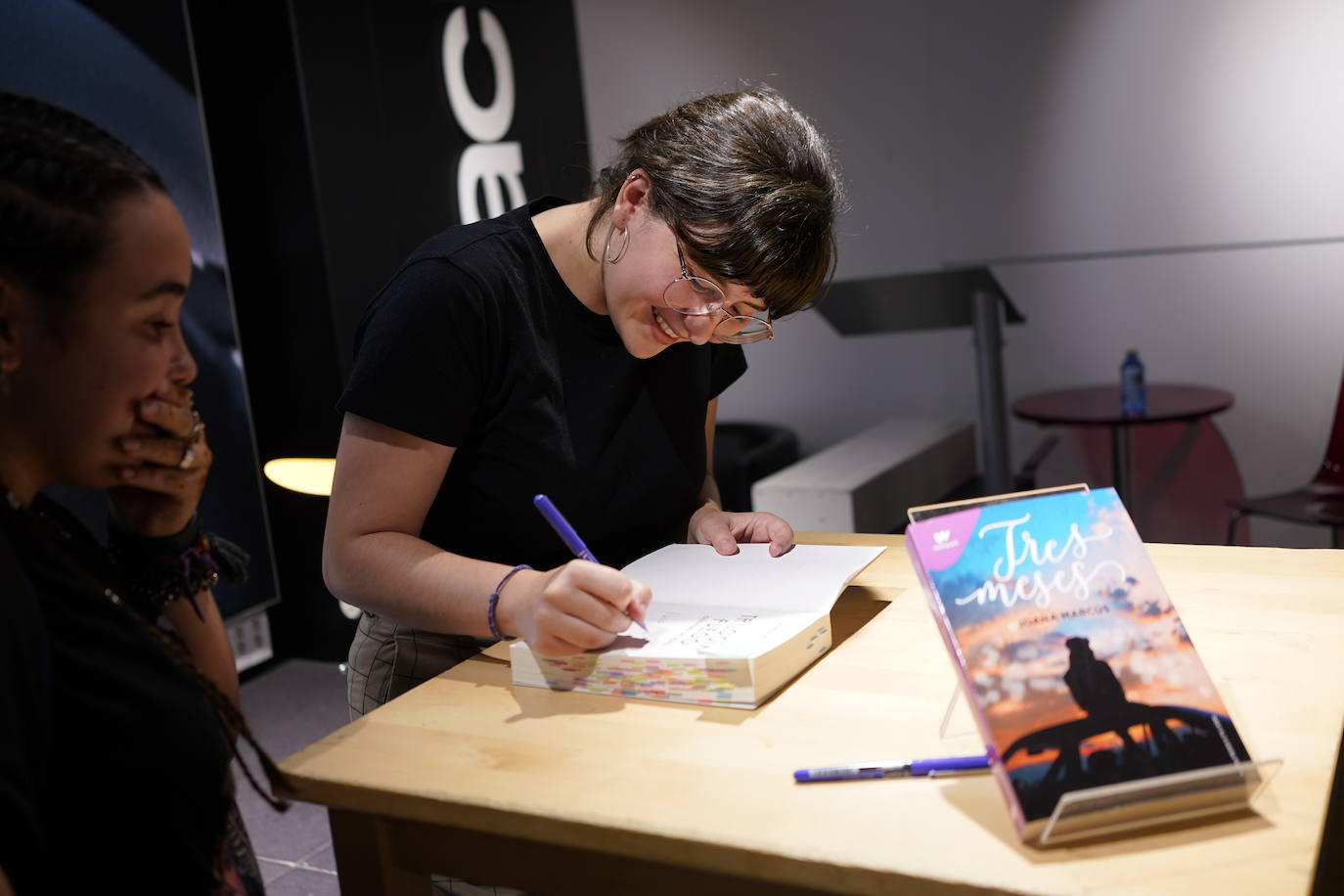 Joana Marcús firmando un libro a una fan.