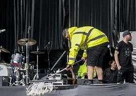 Operarios del Azkena retiran el agua acumulada sobre uno de los escenarios del recinto.