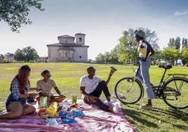 Jóvenes disfrutan de una merienda y del buen tiempo en las campas de Armentia.