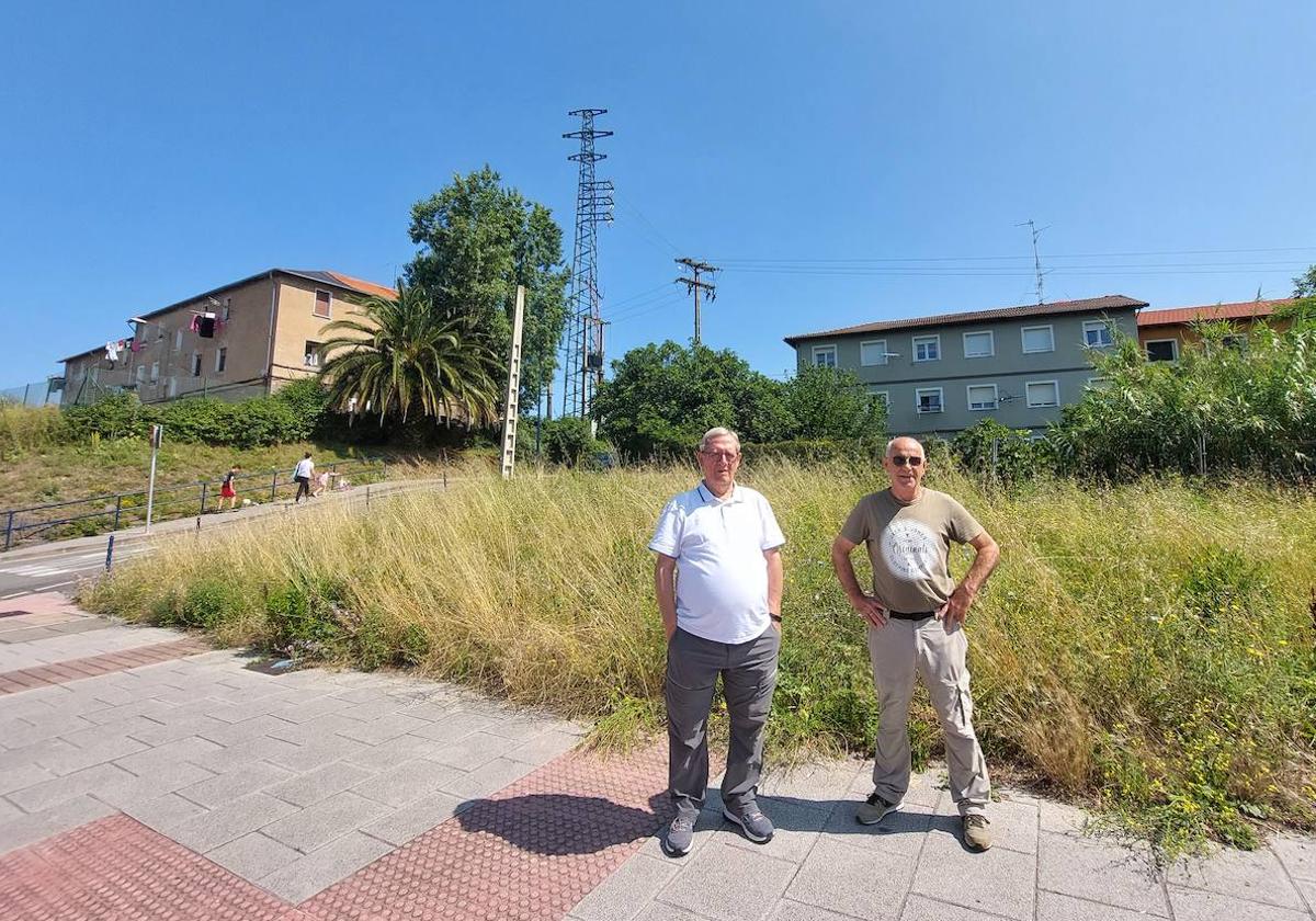 Miguel Manceras y Jesús Pocero, con sus casas al fondo y delante de los terrenos donde serán realojados.