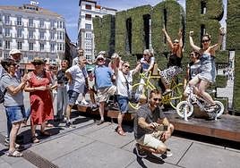Un grupo de turistas bromea con las bicis del Tour en el seto 'green'.
