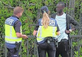 Dos policías identifican a un migrante.