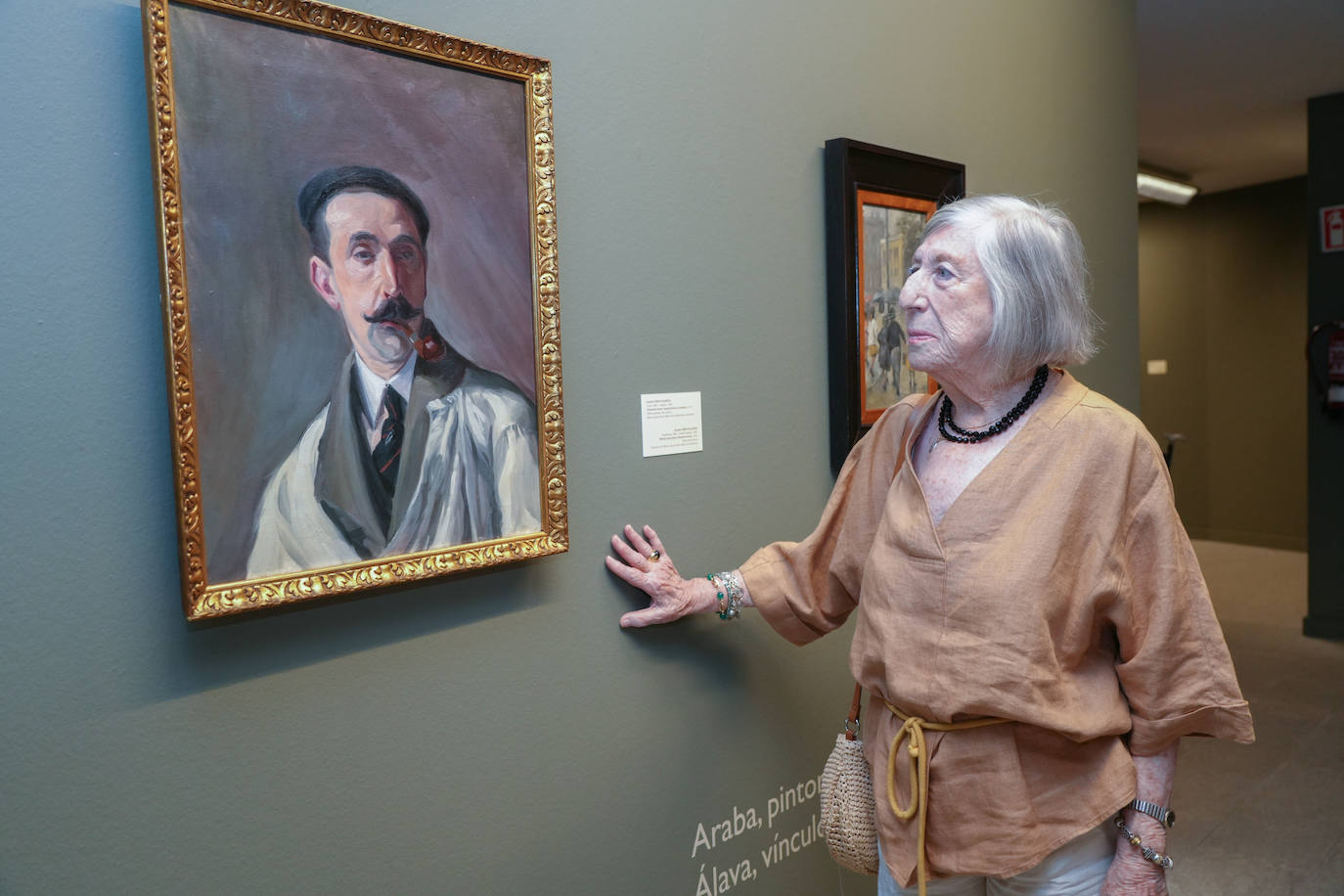 María José Arraiz junto a una pintura en la que aparece retratado su abuelo y 'Bajo la lluvia' de su padre Jesús Arraiz.