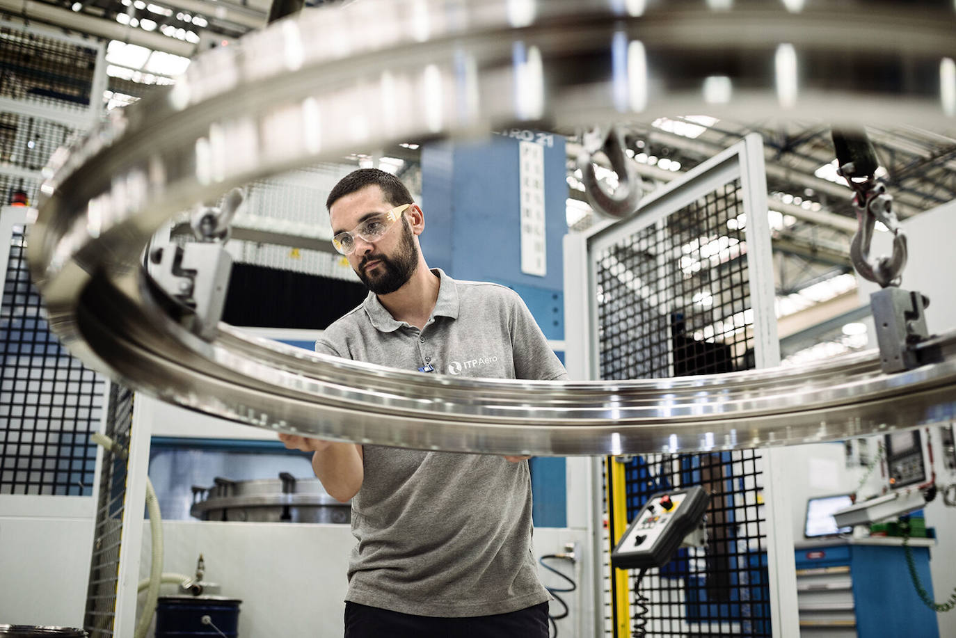 Un emplado de ITP manejando uno de los componentes de un motor de avión.