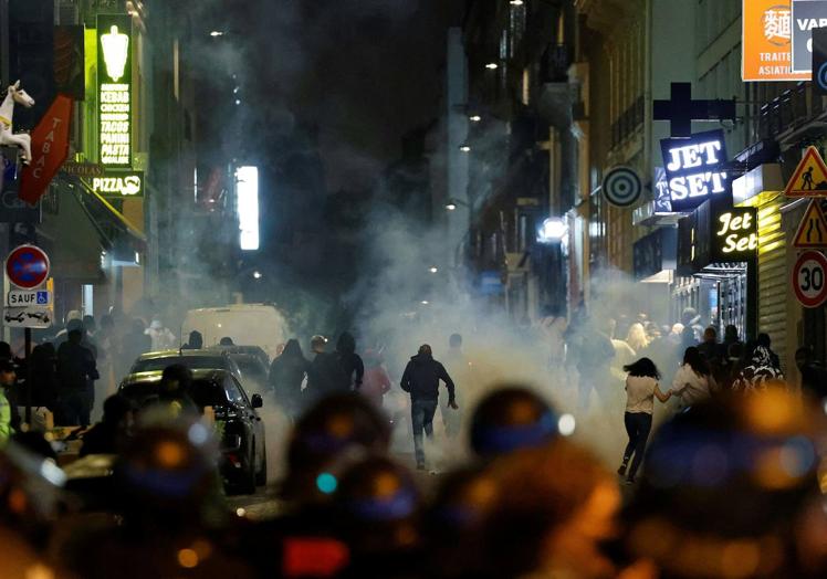 Manifestantes corren mientras la Policía utiliza gas.