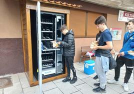 Alumnos del instituto de Etxebarri rellenan la máquina de vending con comida, dentro del proyecto Rexcatering.