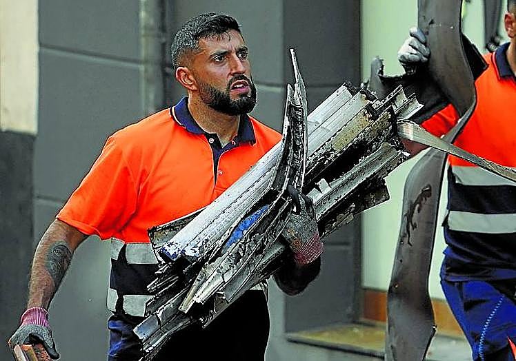 Un operario retira escombros.