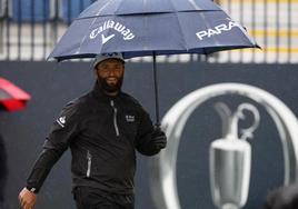 Rahm se protege con un paraguas durante el entrenamiento en el Royal Liverpool Golf Club.