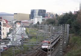 Un tren de Cercanías atraviesa el barrio de Olabeaga, con San Mamés y la escuela de Ingenieros.