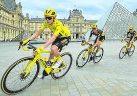 Jonas Vingegaard, seguido por dos corredores de su equipo al paso por la pirámide del Louvre, en la etapa final del Tour 2023.