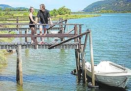 Una pareja se asoma a un embarcadero junto a la pastilla de terreno de los astilleros de Murueta donde se quiere levantar el museo.