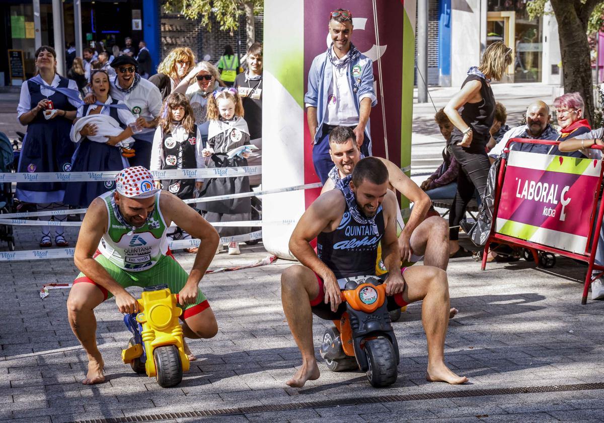 Los tres primeros competidores del triatlón empujan su tricicloen la salida