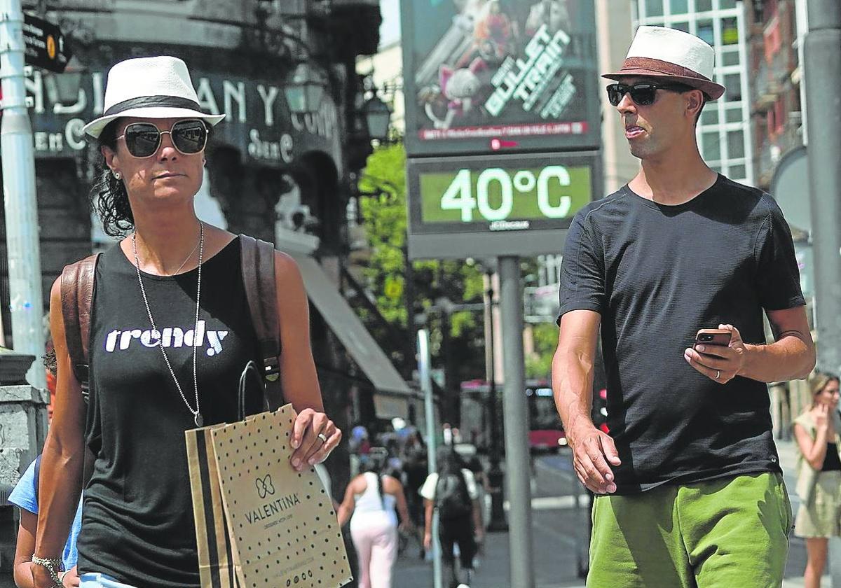 Dos personas caminan por Bilbao durante una ola de calor.