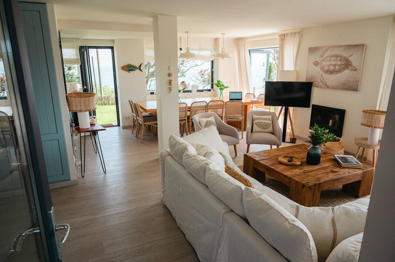 Salón con chimenea y vistas al jardín y a la playa de Oyambre.