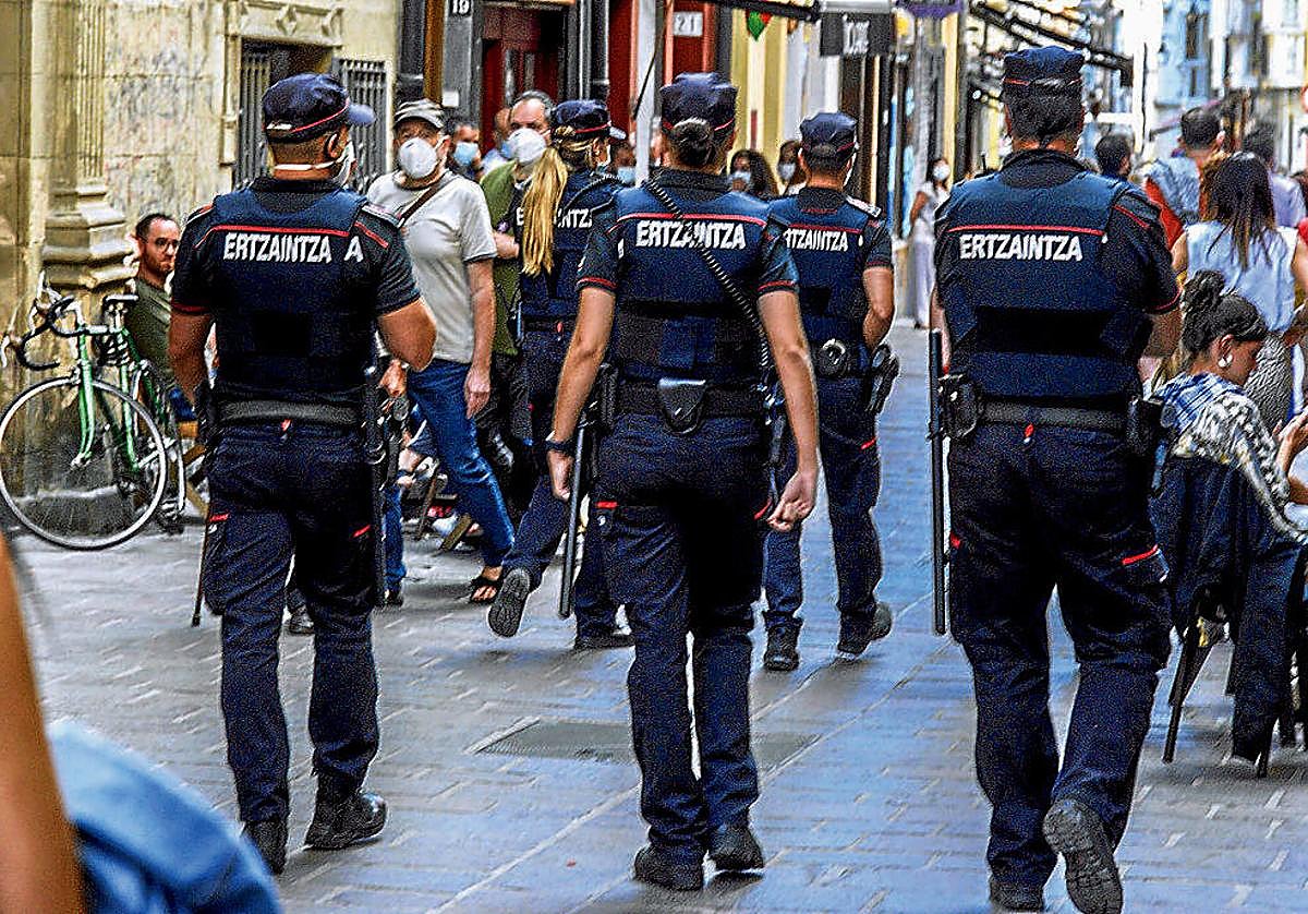 Ertzainas patrullan a pie por una calle de Vitoria.