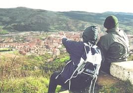 Dos montañeros escrutan el horizonte desde el castro del Malmasin.