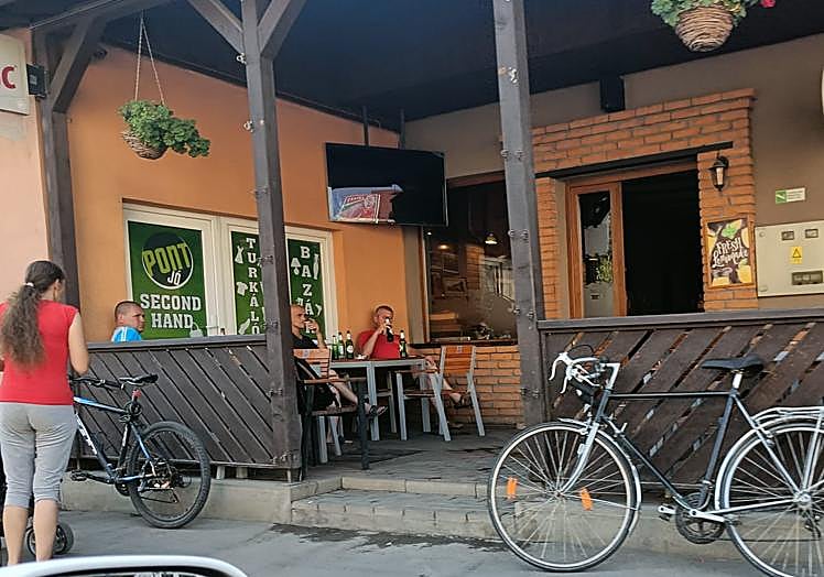 Imagen principal - La terrza de un bar de la ciudad. Horarios de autobuses en húngaro. La bandera de los sículos.