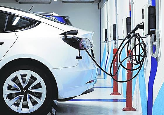 Un automóvil eléctrico recarga sus baterías en los postes habilitados en un aparcamiento público.